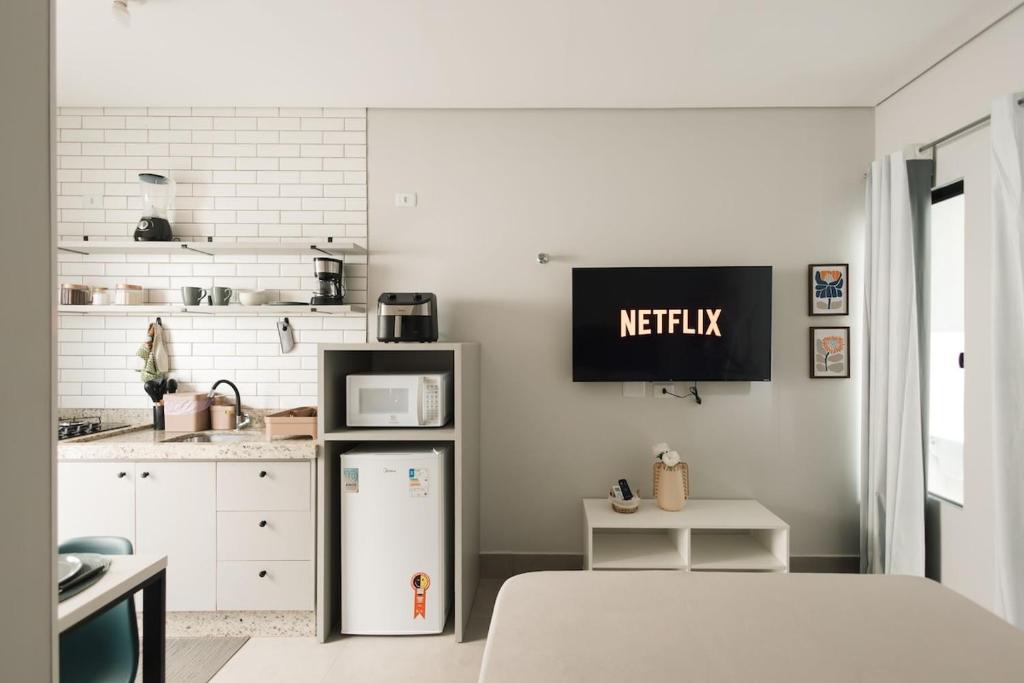 a kitchen with a refrigerator and a microwave at 4-Studio Completo com Ar-Condicionado, TV e Lavanderia in Londrina