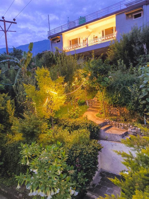 a house on top of a hill with a garden at Cedar Crest Homestay in Kulu