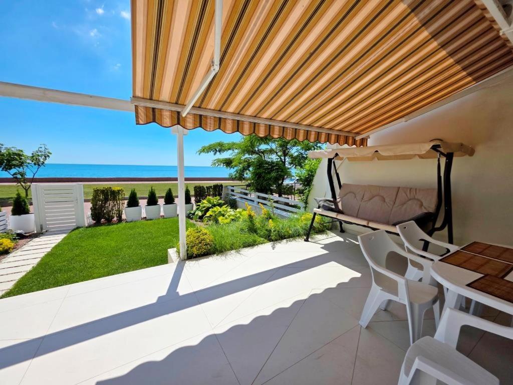 a patio with a table and chairs and a view of the ocean at Приватний Пляж та Релакс у моря без сторонніх in Odesa