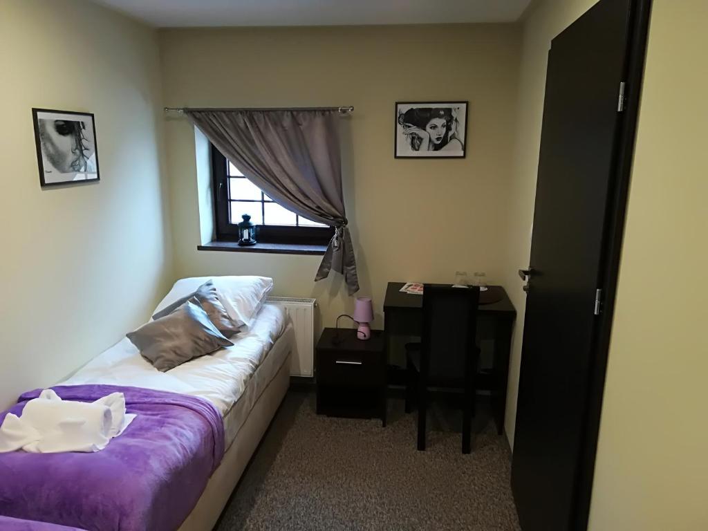 a bedroom with a bed and a desk and a window at Młyn in Chodecz