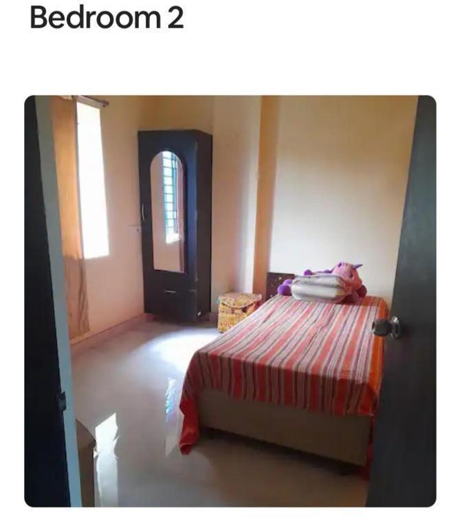 a bedroom with a bed with a red and white blanket at Sir Residency in Howrah