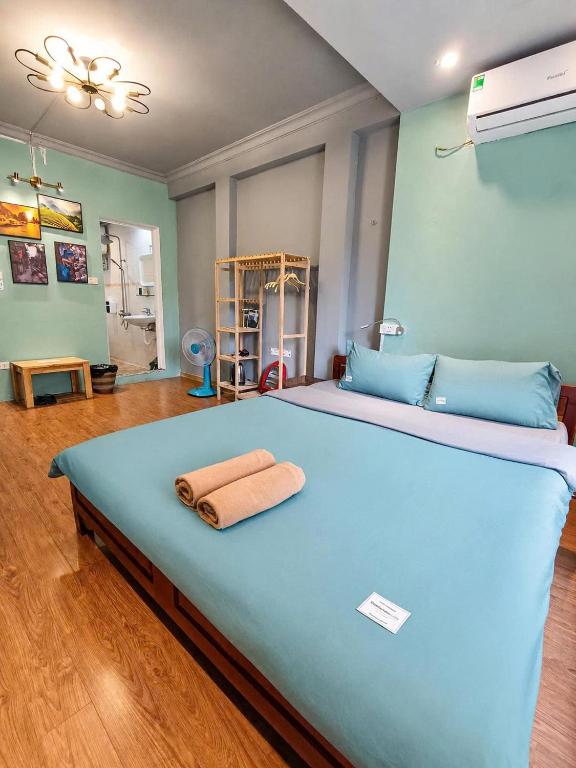 a large blue bed with a towel on top of it at Hanowood Homestay - Renovated since June 2026 in Hanoi