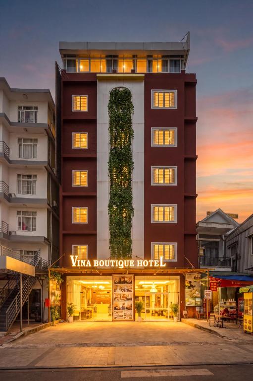 a hotel with a tall building with a ivy covered facade at Vina Boutique Hotel in Hue