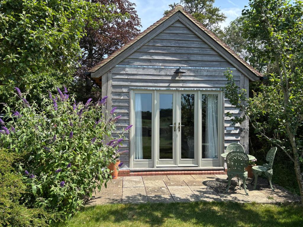 a small house with a sliding glass door at The Lodge at Mortons in Malmesbury