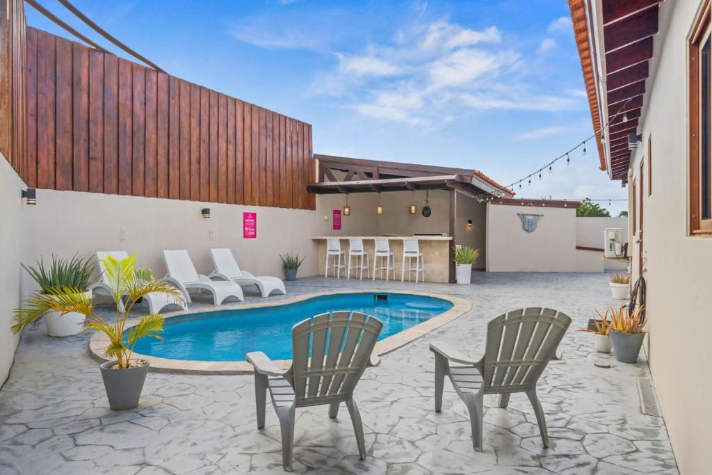 a patio with chairs and a swimming pool at Felicidad 30 in Oranjestad