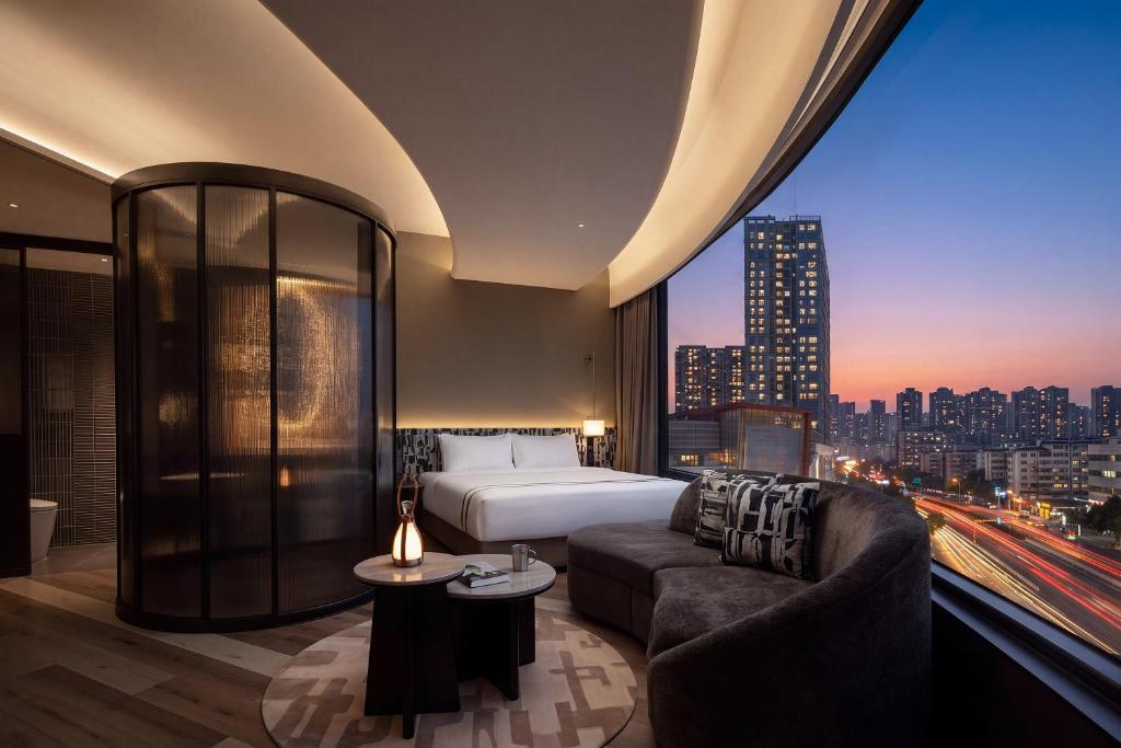 a hotel room with a bed and a large window at YOUNG Hotel Guilin -Mixc Mall in Guilin