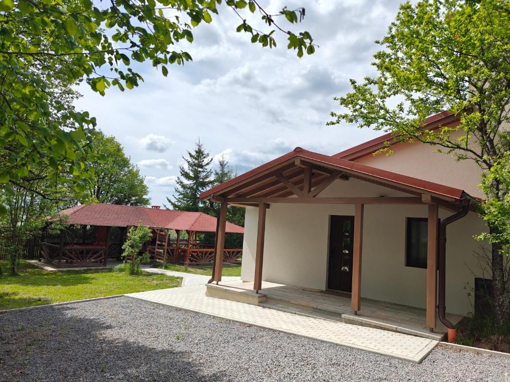 a small building with a porch in a park at Gyulak Guesthouse in Izvoare