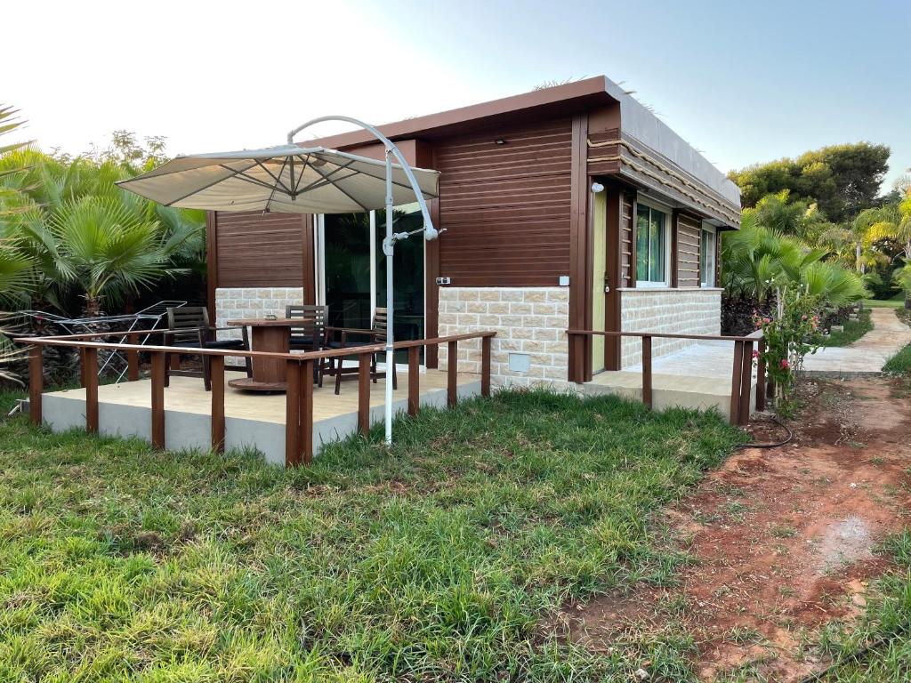 a house with a table and an umbrella at palmeraie4 in Skhirat