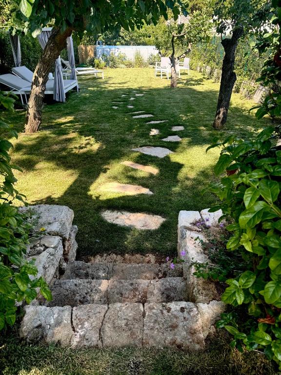 a garden with a stone path in the grass at I Trulli di Federico in Selva di Fasano