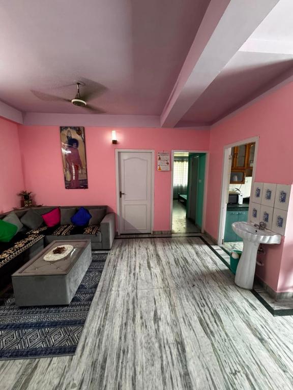 a living room with pink walls and a couch at Subba Stays in Siliguri