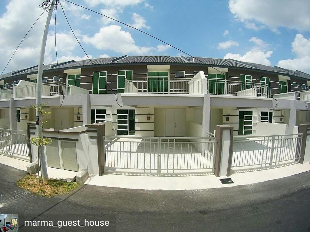a white building with a fence in front of it at MARMA Homestay Melaka in Ayer Keroh