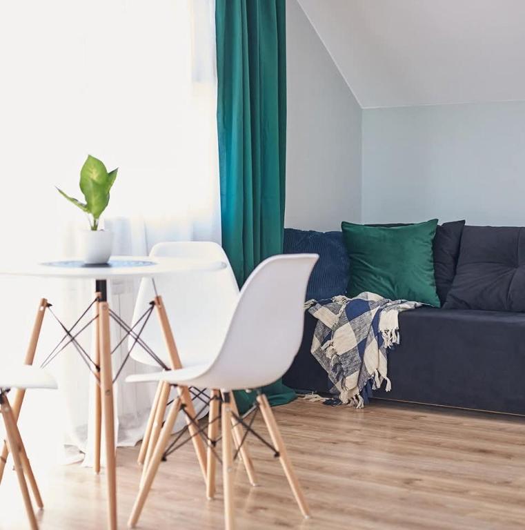 a living room with white chairs and a couch at Pokoje Hotelowe Gościniec in Siedlce