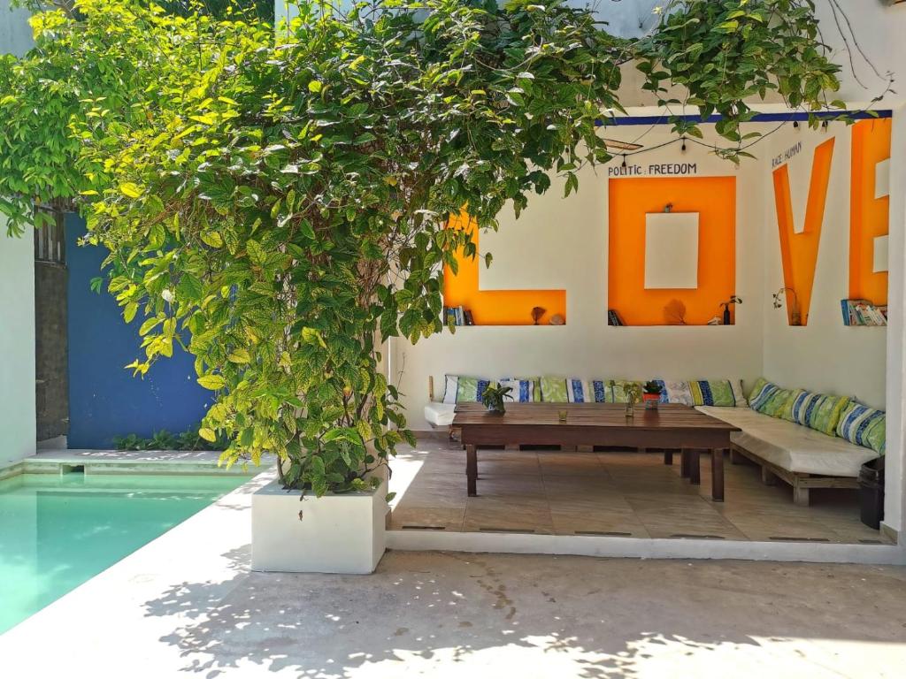 ein Wohnzimmer mit einem Holztisch und einem Baum in der Unterkunft Hostel Humanity - Puerto Morelos in Puerto Morelos