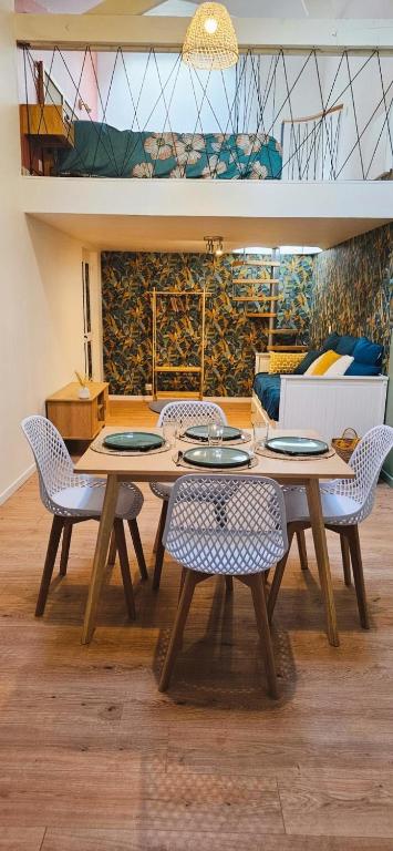 a dining room with a wooden table and chairs at La mie du Hom in Thury-Harcourt