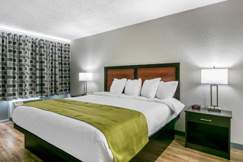 a large bed in a hotel room with two lamps at Rodeway Inn Kingston Springs in Kingston Springs