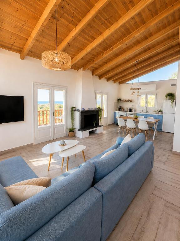 a living room with a blue couch and a table at Villa Keren in Oropos