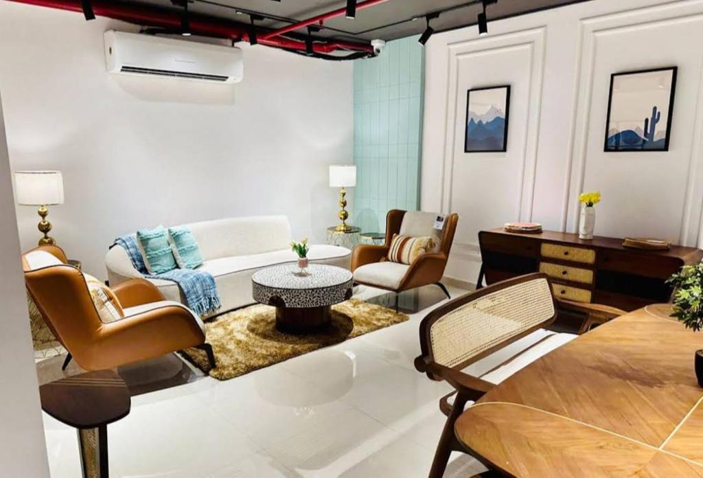 a living room with a couch and chairs and a table at Hotel Prithvi Studio - RDC And Santosh Hospital in Ghaziabad