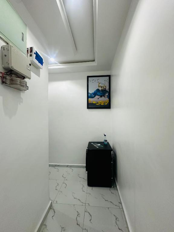 a room with a white wall with a picture on the wall at April shortlet apartments in Lagos