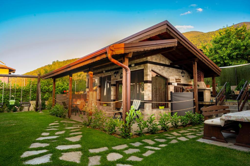 a small house with a garden with a patio at Студио Мурите in Sapareva Banya