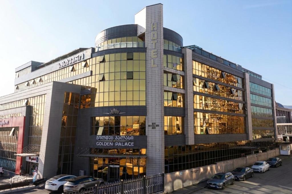 a large building with cars parked in front of it at Golden Palace Hotel in Tbilisi City