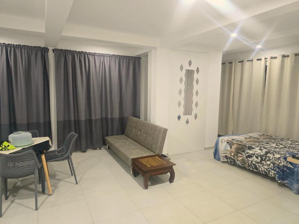 a bedroom with a couch and a bed and a table at Beach 2 Min - Bright Central Studio - AC in Santa Maria