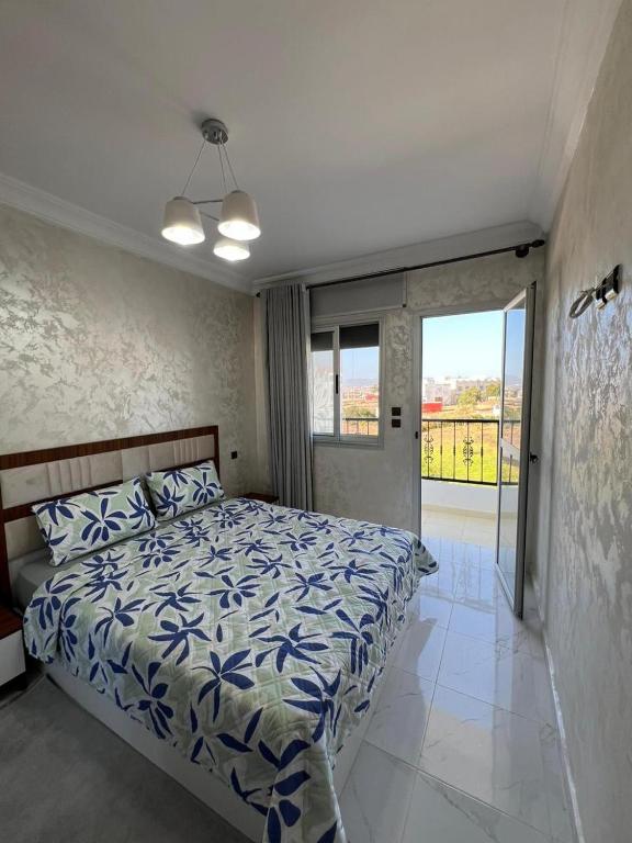 a bedroom with a bed with a blue and white comforter at nader s in Hajreien