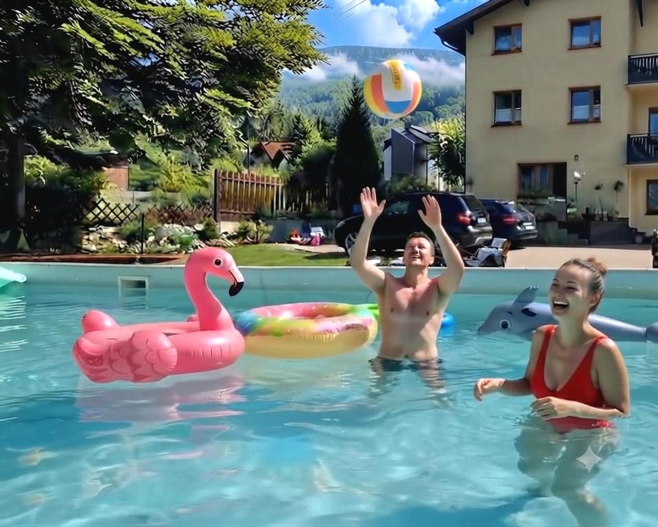 two boys playing with a ball in a swimming pool at Nova Szymusiowa in Szczyrk