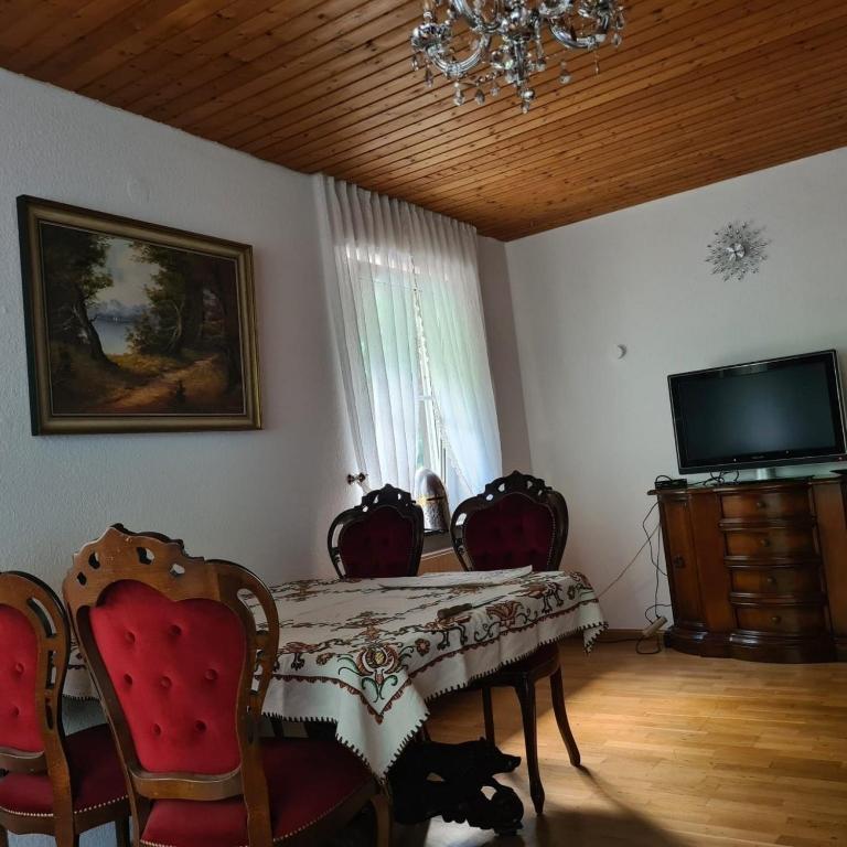 a dining room with a table and chairs and a television at Haus Nummer 7 in Manderscheid