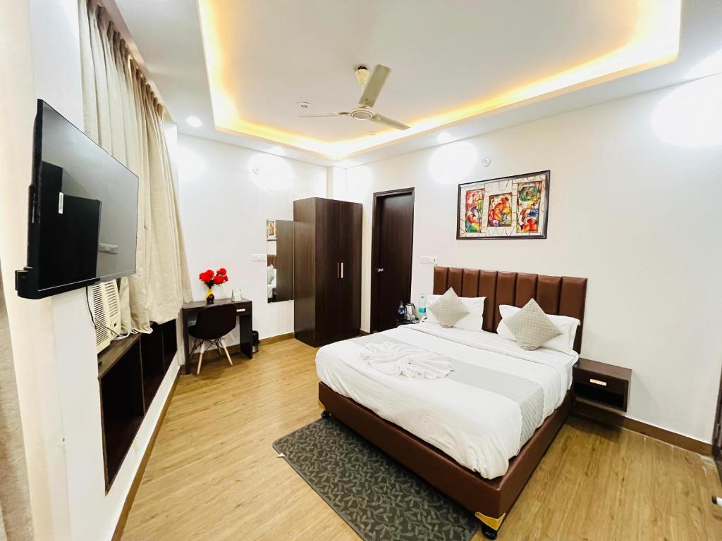 a bedroom with a bed and a flat screen tv at Hotel PP Tower - Near Ghaziabad Railway Station in Ghaziabad
