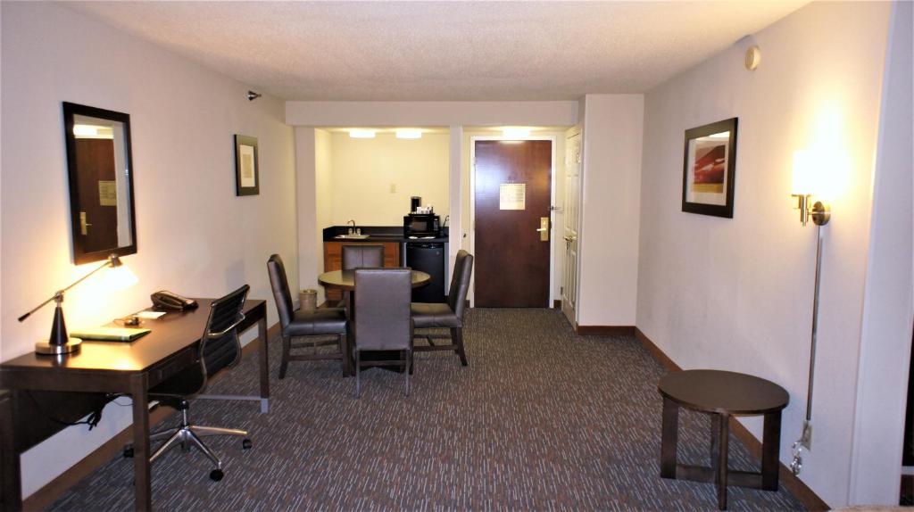a hotel room with a desk and a table and chairs at Wingate by Wyndham - Chattanooga in Chattanooga
