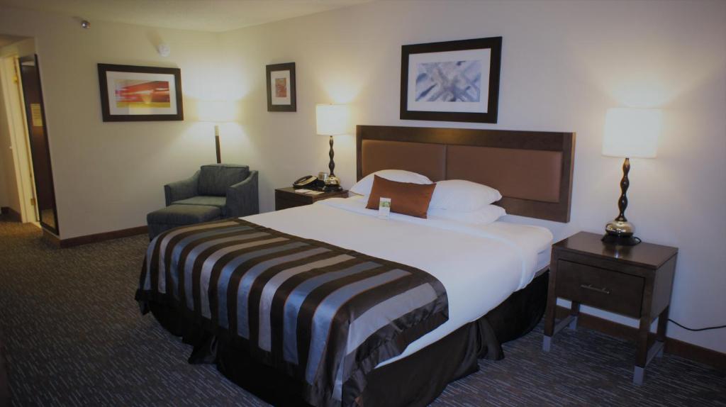 a hotel room with a large bed and a chair at Wingate by Wyndham - Chattanooga in Chattanooga