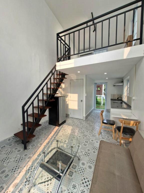 a living room with a staircase and a table at River View Villas in Vang Vieng