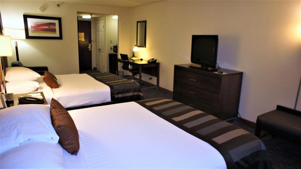 a hotel room with two beds and a flat screen tv at Wingate by Wyndham - Chattanooga in Chattanooga