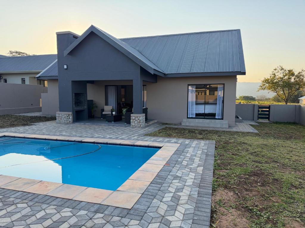 a house with a swimming pool in front of it at Natures Nest with Mongi Hazyview in Hazyview
