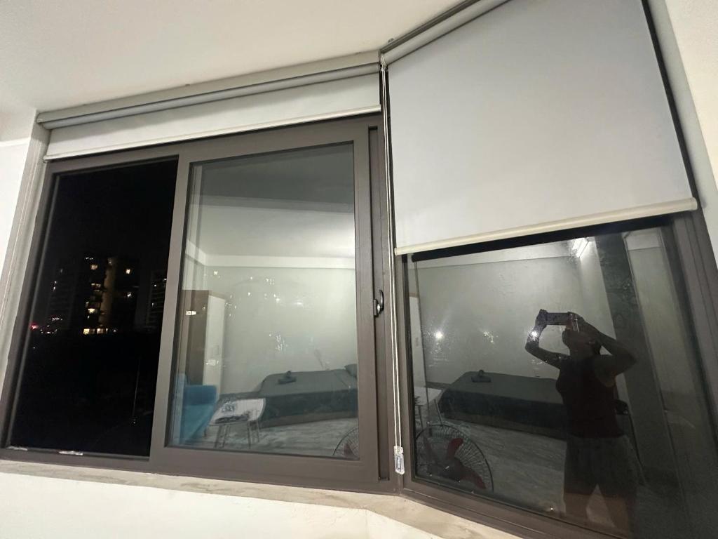 a person taking a picture of a window at Mayhome in Long Biên
