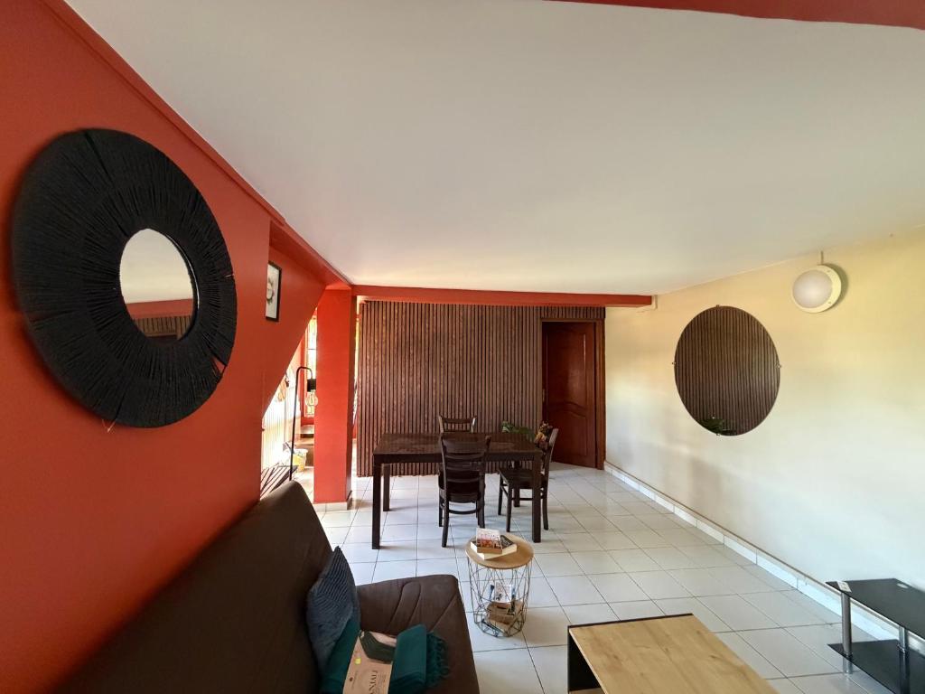 a living room with red walls and a table at Appartement vu sur mer in Mamoudzou