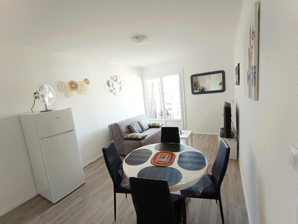 a living room with a table and chairs and a couch at APPARTEMENT à 5 mn de la plage in Saint-Hilaire-de-Riez