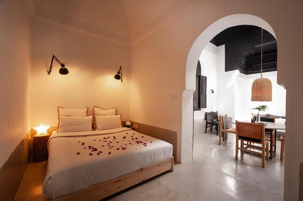 a bedroom with a bed and a dining room at Riad Sahara - Private House Rooftop Medina Marrakech in Marrakesh