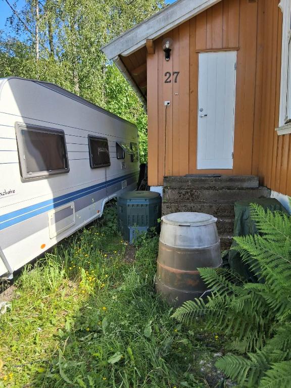 a trailer parked next to a house with a barrel at Hobby 750 caravan in Oslo