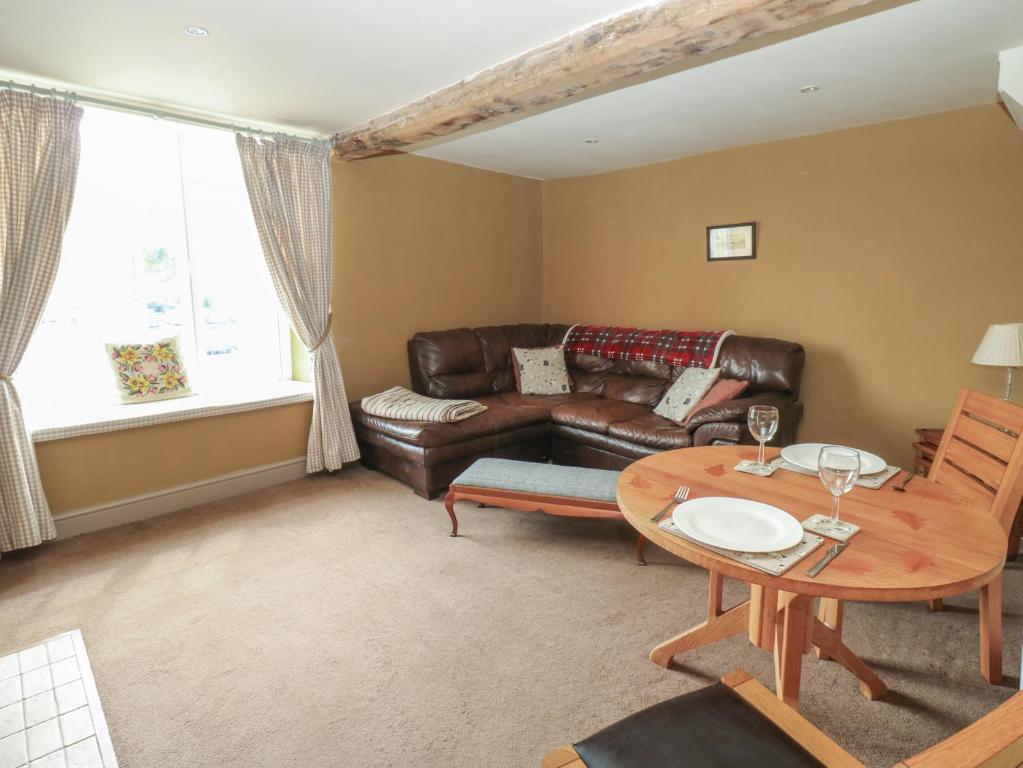 a living room with a leather couch and a table at Ewe Cottage in Ripon