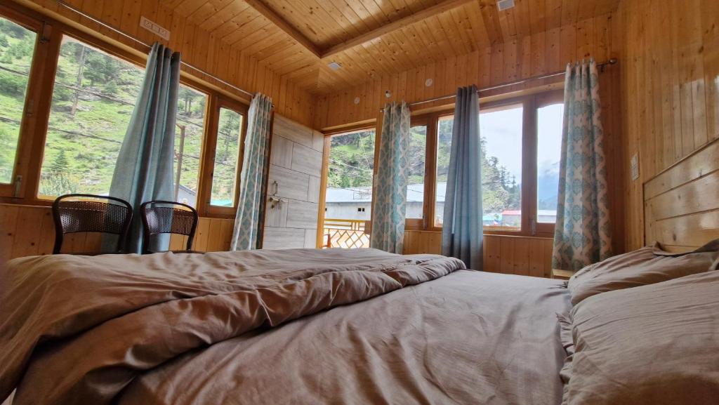 a bedroom with a bed in front of some windows at Daisy Divine in Harsil