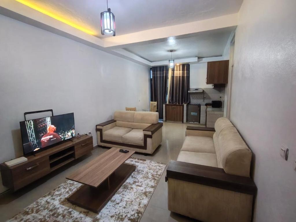 a living room with a couch and a tv at Mtg Apartment in Rubavu