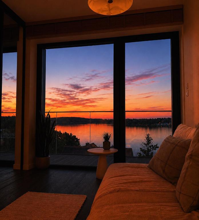 a room with a bed and a view of a sunset at ViP PRATUM in Mikołajki