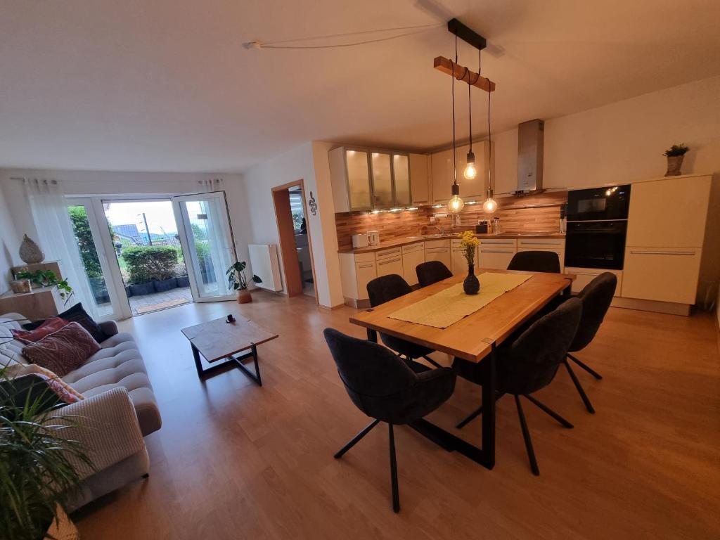 a living room with a wooden table and chairs at Modernes Apartment mit Terasse in Lügde