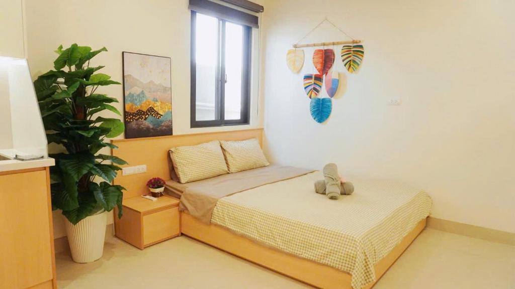 a bedroom with a bed with a teddy bear on it at Harmony apartment in Noi Bai