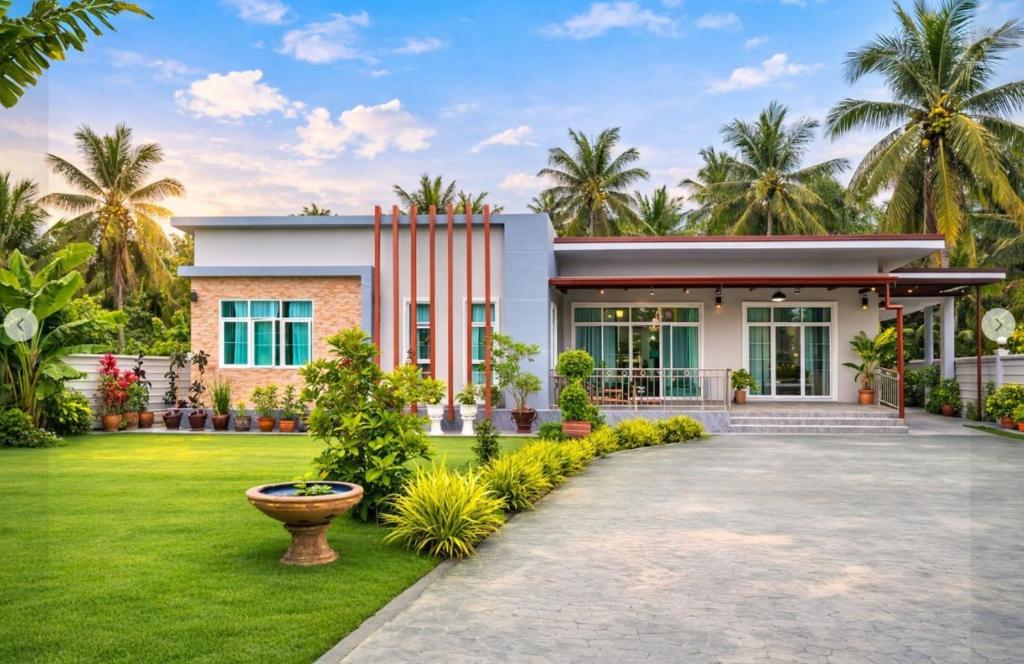 a house with a lawn in front of it at Mae Klong Garden House แม่กลอง การ์เด้น เฮ้าส์ in Samut Songkhram