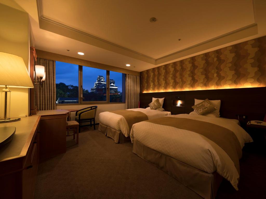 a hotel room with two beds and a window at KKR Hotel Kumamoto in Kumamoto