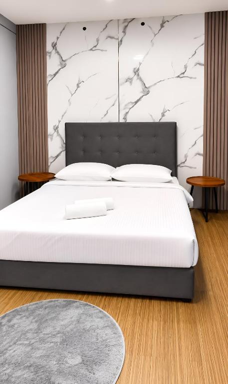 a bedroom with a large bed with white sheets at Neela Homestay in Labuan