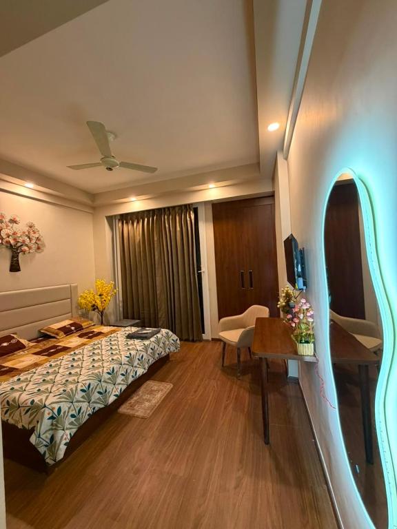 a hotel room with a bed and a desk and a table at Max Stays in Greater Noida