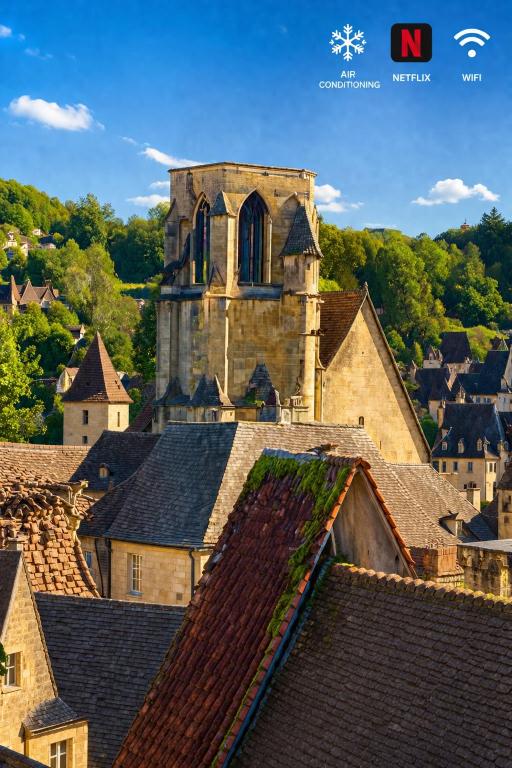 an old church sitting on top of roofs at FRANRÉAL, 4 Appartements Climatisés in Sarlat-la-Canéda